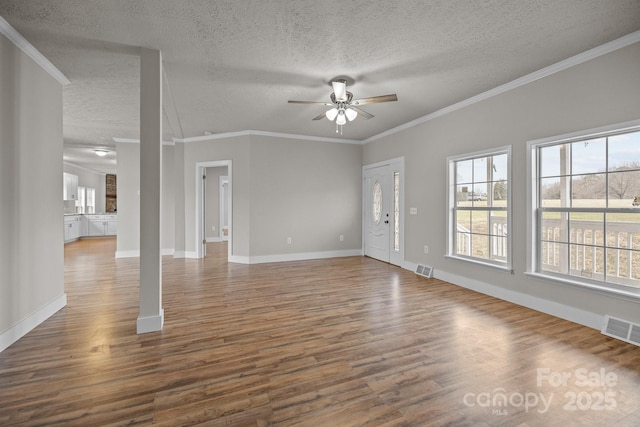 unfurnished living room featuring ornamental molding, dark hardwood / wood-style floors, a textured ceiling, and ceiling fan