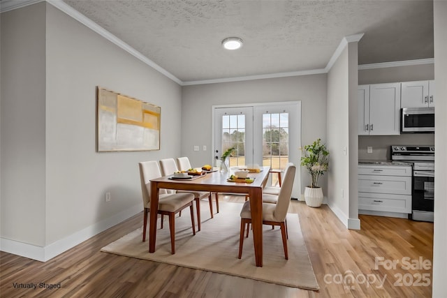 dining room with crown molding, a textured ceiling, and light wood-type flooring