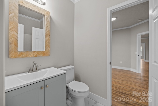 bathroom featuring vanity, hardwood / wood-style floors, crown molding, and toilet