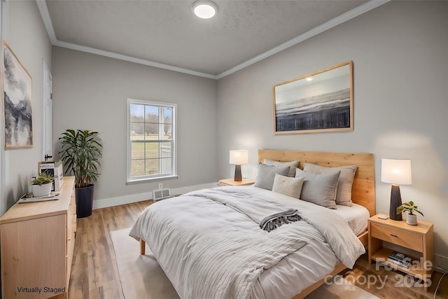 bedroom with crown molding and light hardwood / wood-style flooring