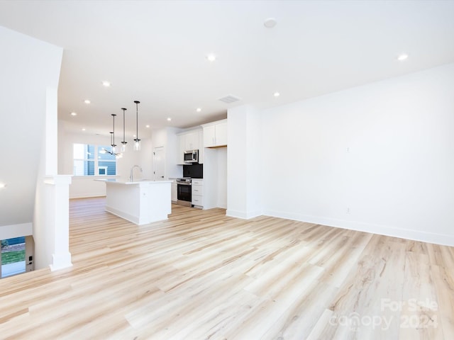 7022 Impulse Ct, Charlotte, NC 28205 - unfurnished living room featuring light wood finished floors and recessed lighting