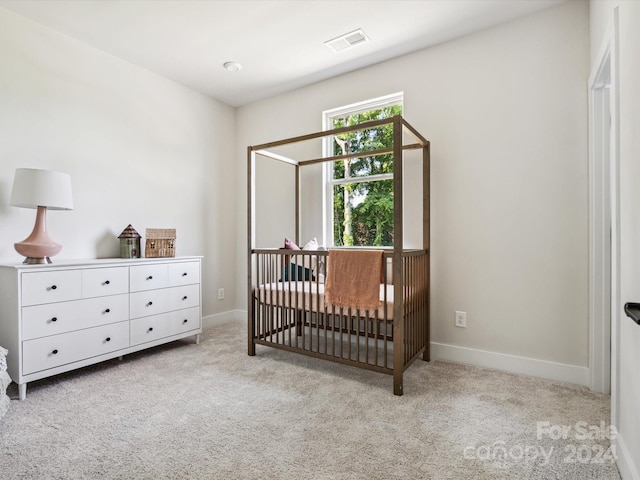 carpeted bedroom with a nursery area