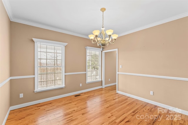 unfurnished room with crown molding, a chandelier, and light hardwood / wood-style flooring