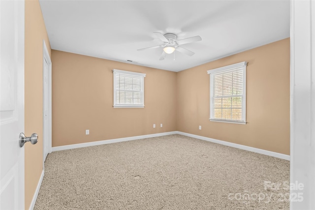 spare room featuring carpet floors, a healthy amount of sunlight, and ceiling fan