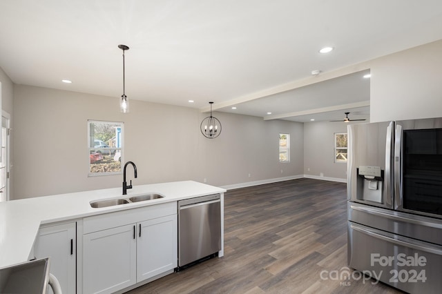 kitchen featuring white cabinets, sink, decorative light fixtures, dark hardwood / wood-style flooring, and stainless steel appliances