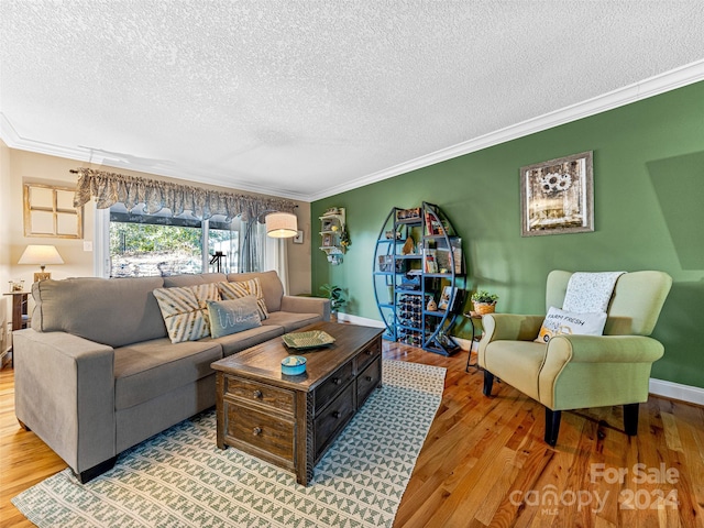 living room featuring crown molding, light hardwood / wood-style floors, and a textured ceiling