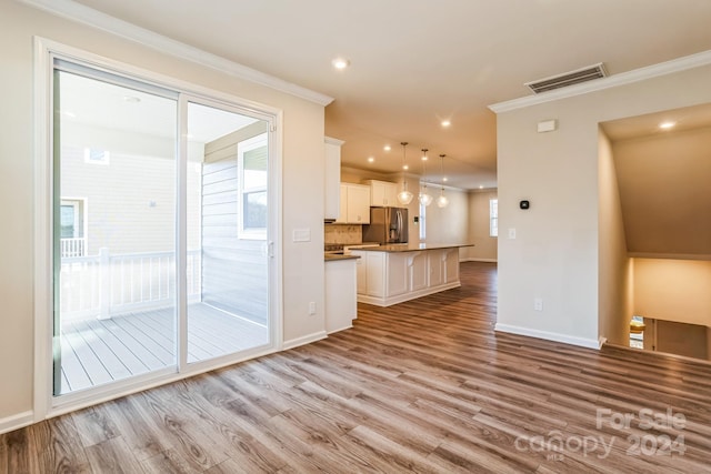 unfurnished living room with crown molding and light hardwood / wood-style flooring