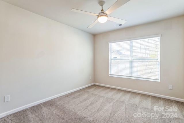 carpeted spare room featuring ceiling fan