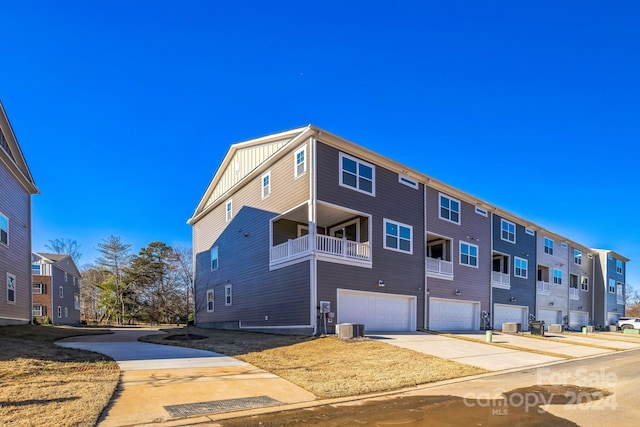 exterior space featuring a balcony, central AC unit, and a garage