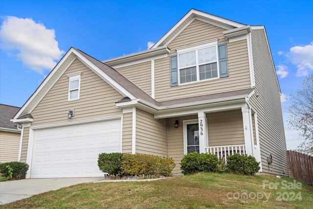 front of property featuring covered porch, a front yard, and a garage