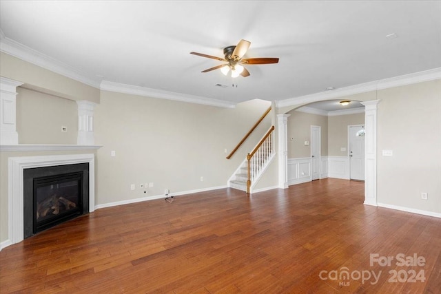 unfurnished living room featuring ceiling fan, dark hardwood / wood-style flooring, and ornamental molding