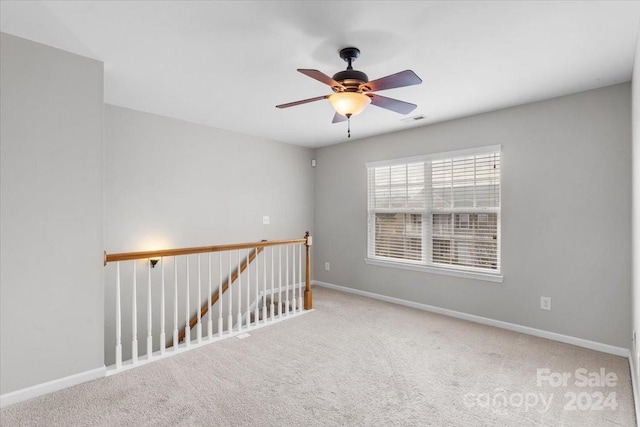 spare room featuring ceiling fan and carpet floors