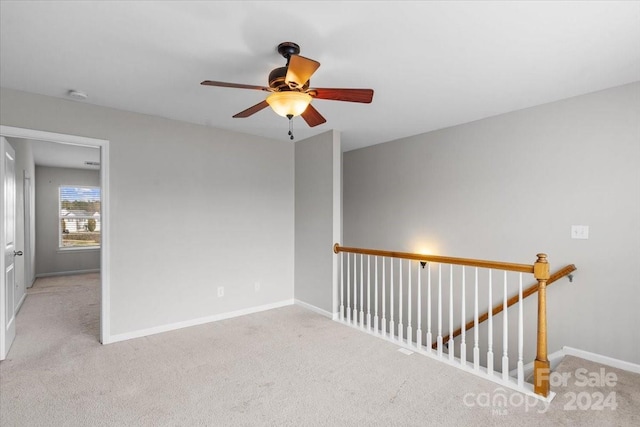 empty room with light colored carpet and ceiling fan