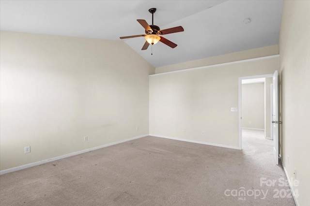 spare room with ceiling fan, light carpet, and vaulted ceiling