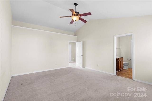 unfurnished bedroom featuring ceiling fan, light colored carpet, ensuite bathroom, and high vaulted ceiling