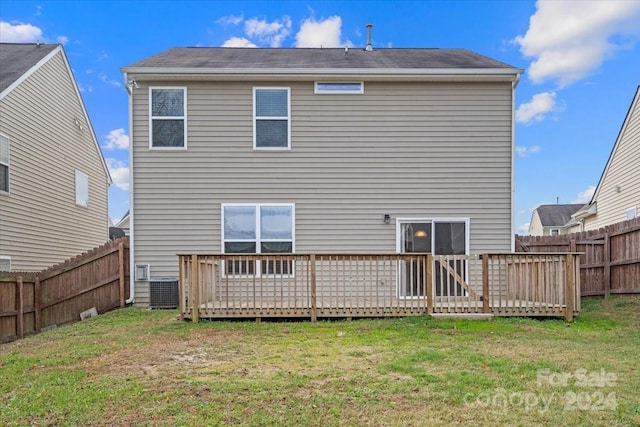 back of property with a lawn and a deck