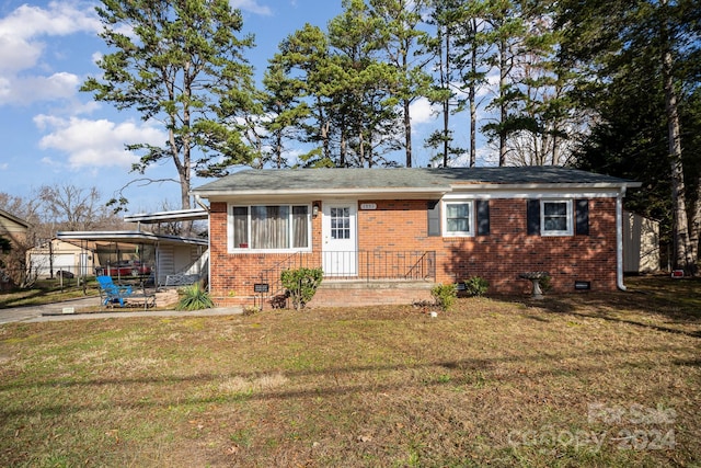 view of front of home with a carport and a front lawn