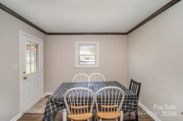 dining space featuring wood-type flooring and crown molding