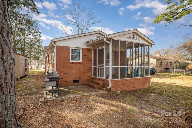 back of property featuring a sunroom and a patio