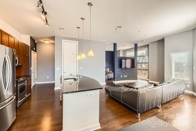 kitchen featuring dark hardwood / wood-style flooring, sink, stainless steel appliances, and decorative light fixtures