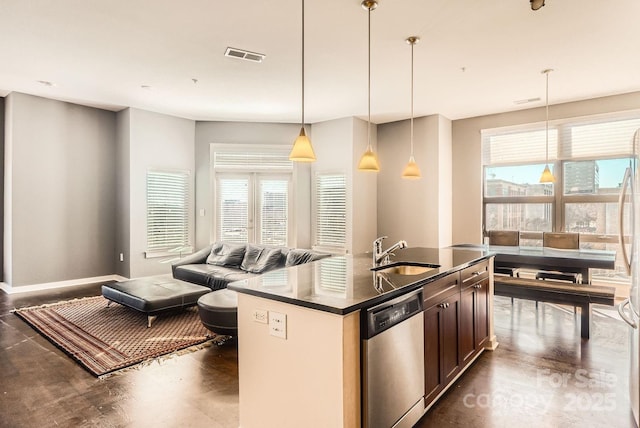 kitchen featuring stainless steel dishwasher, sink, decorative light fixtures, plenty of natural light, and an island with sink