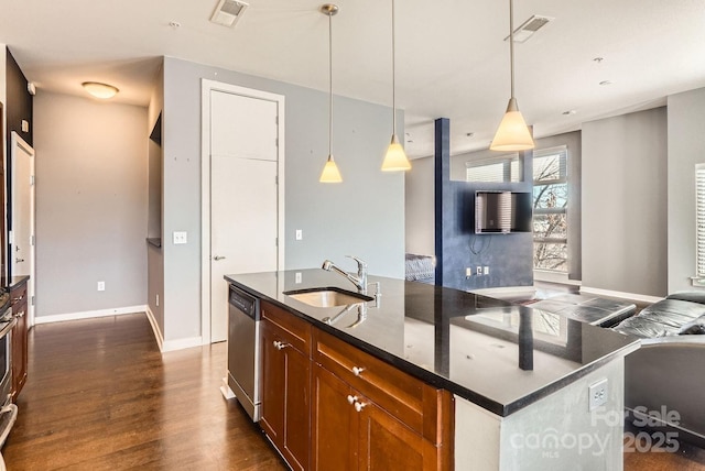 kitchen with dishwasher, sink, dark stone countertops, an island with sink, and decorative light fixtures