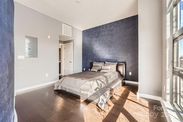 bedroom featuring electric panel and dark wood-type flooring