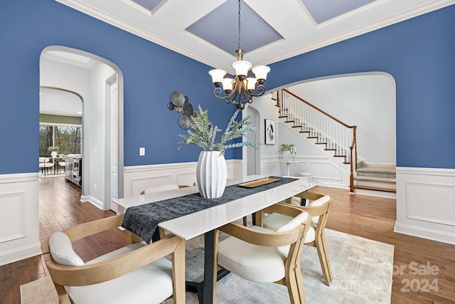 dining area featuring dark hardwood / wood-style flooring, an inviting chandelier, and crown molding