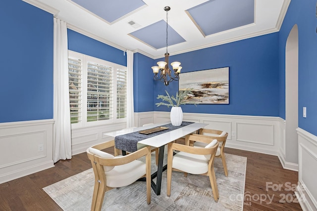 dining space featuring ornamental molding, dark wood-type flooring, and an inviting chandelier