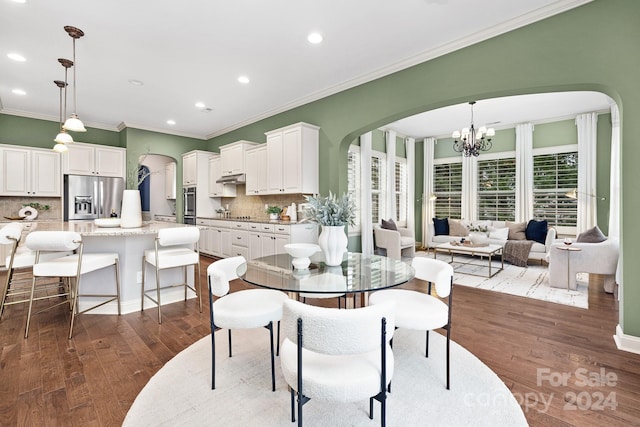 dining area with a chandelier, dark wood-type flooring, and ornamental molding