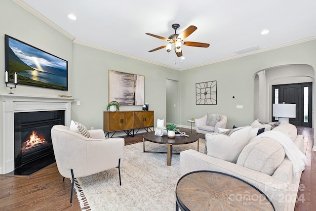 living room with hardwood / wood-style floors, ceiling fan, and crown molding