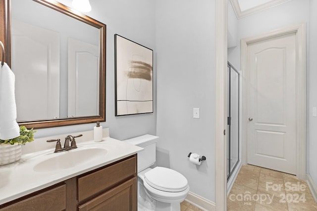 bathroom featuring vanity, crown molding, tile patterned flooring, toilet, and walk in shower