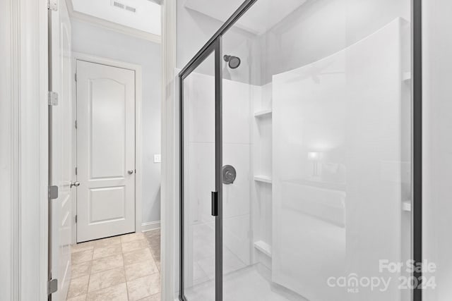 bathroom featuring tile patterned floors, crown molding, and walk in shower