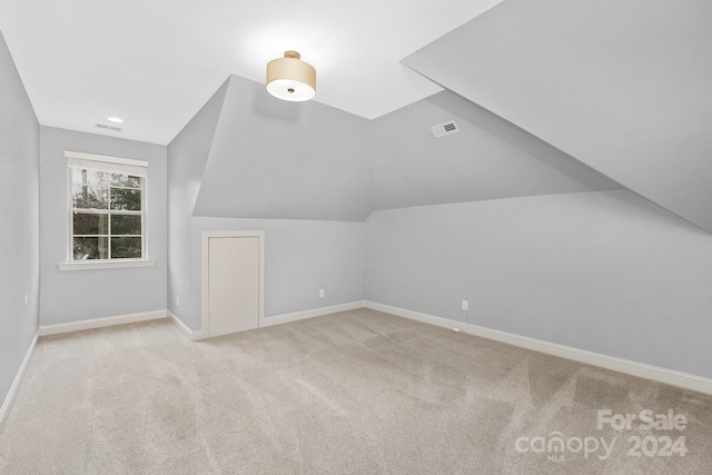 bonus room with light carpet and lofted ceiling