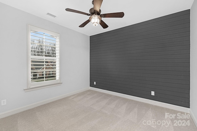 unfurnished room with light colored carpet and ceiling fan