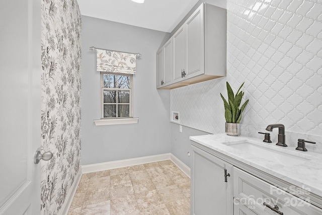 laundry room with hookup for a washing machine, sink, and cabinets