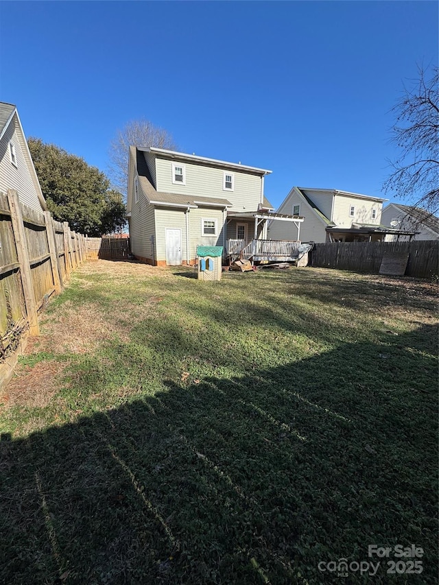 back of house featuring a deck and a yard