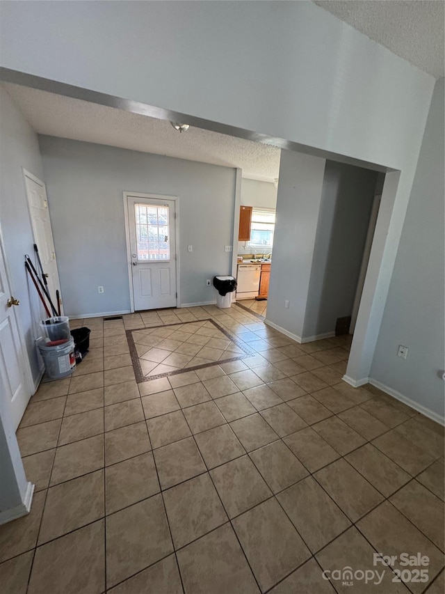 tiled entryway featuring a textured ceiling