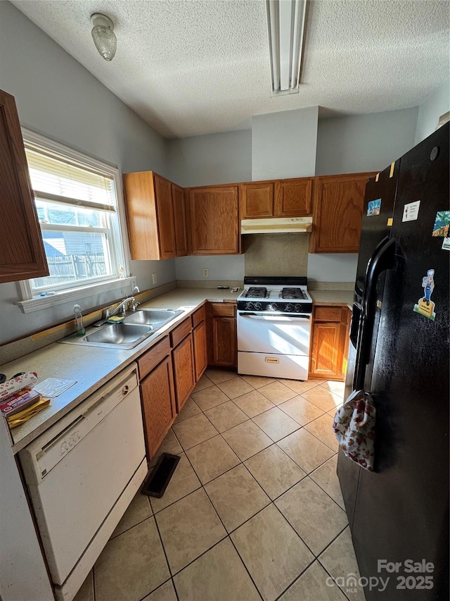 kitchen featuring sink, white appliances, a textured ceiling, and light tile patterned flooring