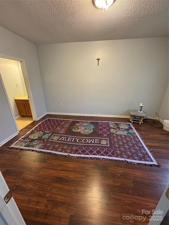 empty room featuring wood-type flooring and a textured ceiling