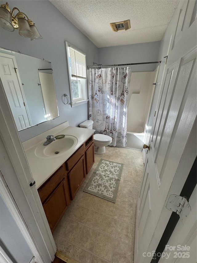 full bathroom featuring toilet, a textured ceiling, shower / bath combination with curtain, tile patterned floors, and vanity