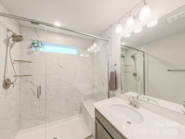 bathroom featuring a shower with door and vanity