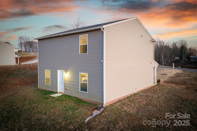 property exterior at dusk with a yard