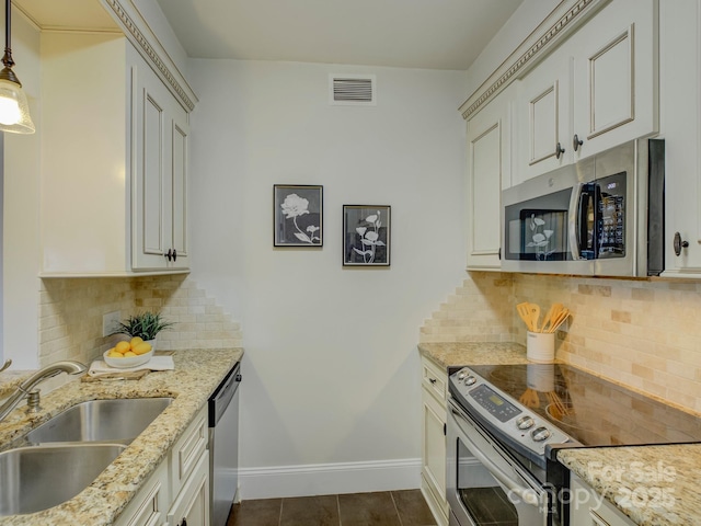 kitchen with light stone countertops, sink, stainless steel appliances, tasteful backsplash, and pendant lighting