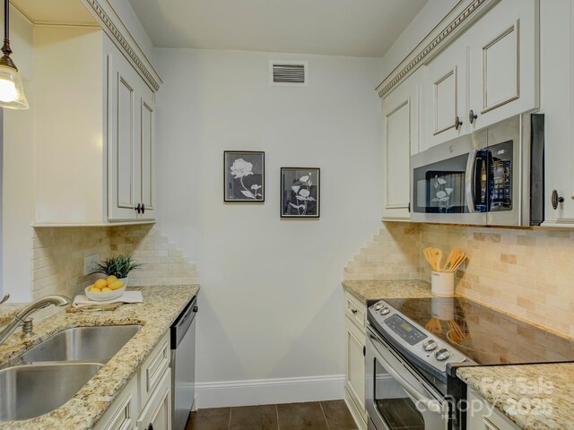 224 N Poplar St Unit 19, Charlotte, NC 28202 - kitchen with appliances with stainless steel finishes, backsplash, light stone countertops, dark tile patterned floors, and decorative light fixtures