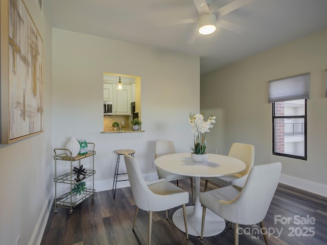 dining area with ceiling fan and dark hardwood / wood-style flooring