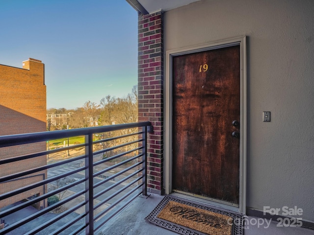 view of exterior entry featuring a balcony