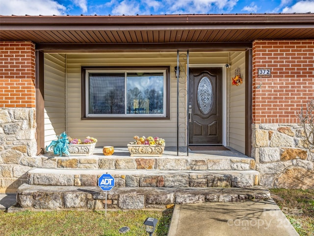 view of exterior entry featuring covered porch