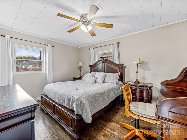 bedroom with dark hardwood / wood-style flooring, ceiling fan, and crown molding