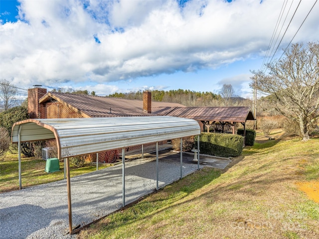 view of parking / parking lot with a carport and a lawn